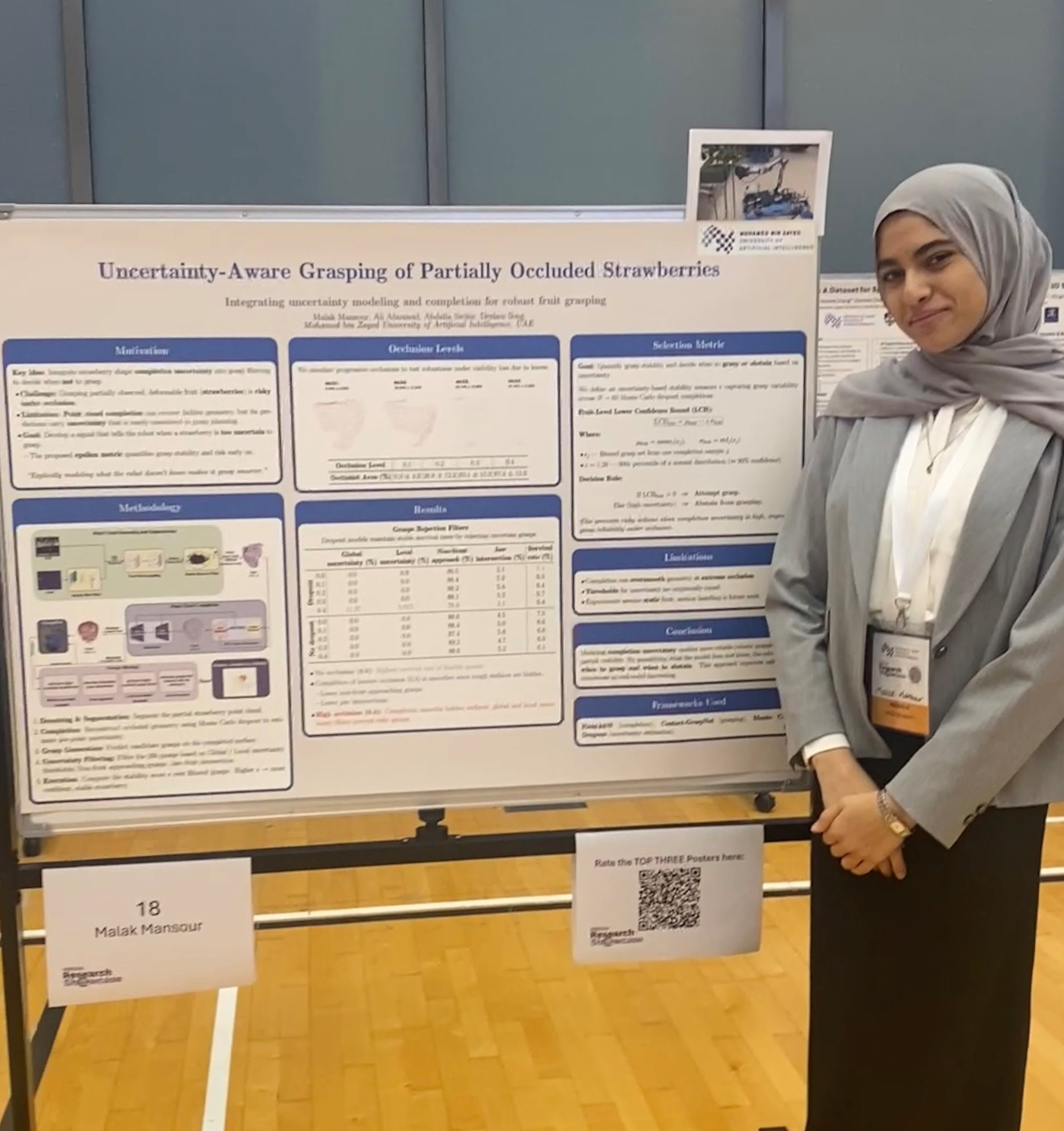 Malak Mansour standing beside her uncertainty-aware grasping research poster