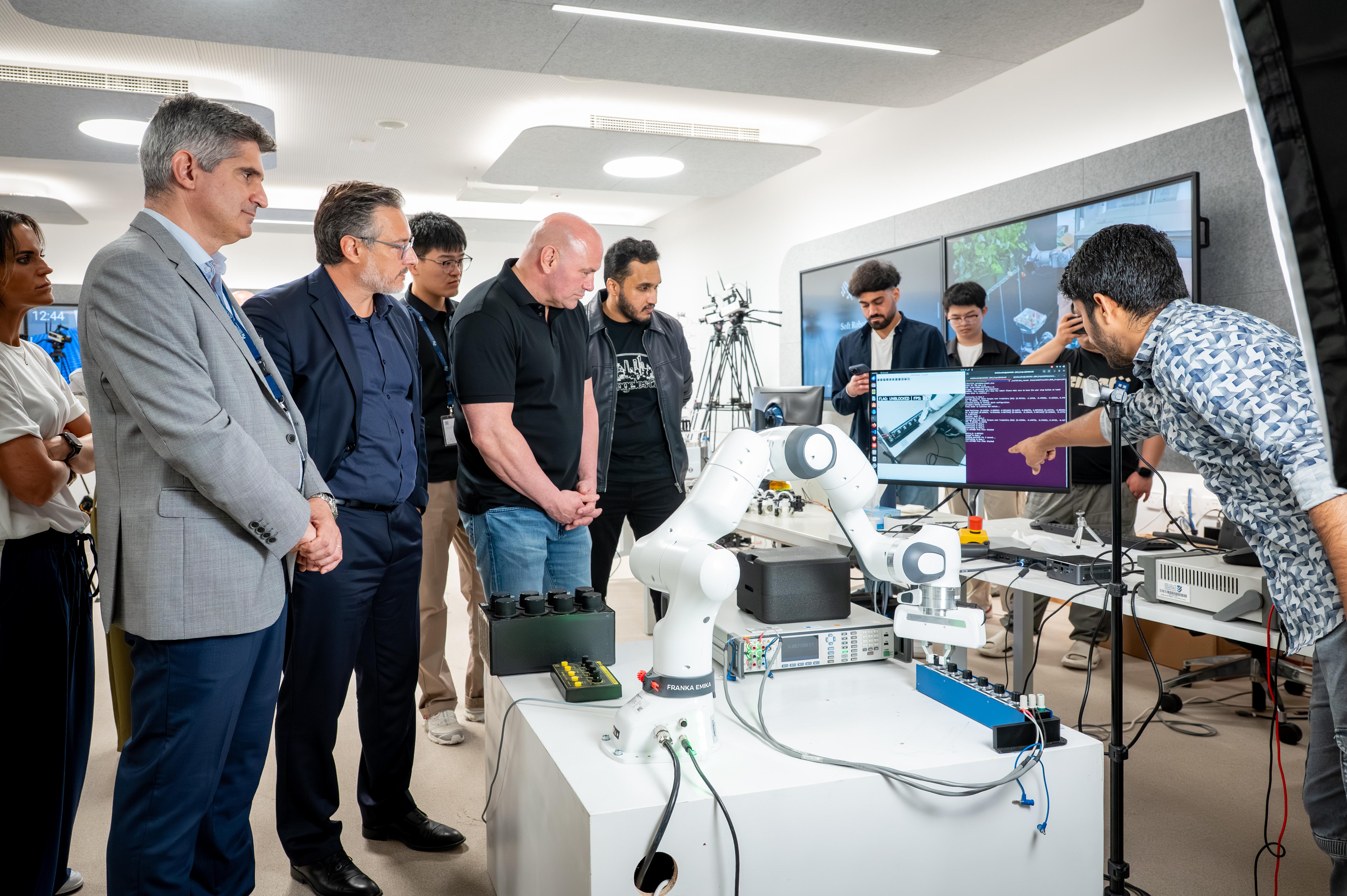 Dana White speaking with researchers in the AIRoCS lab